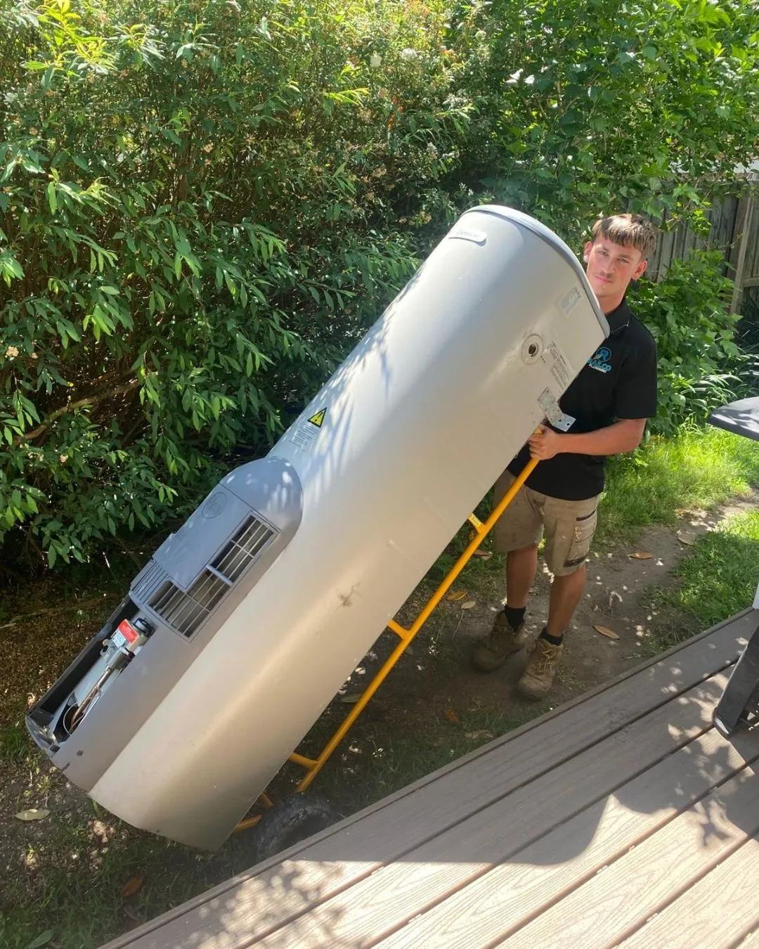 Rae.co plumber carrying a new hot water system